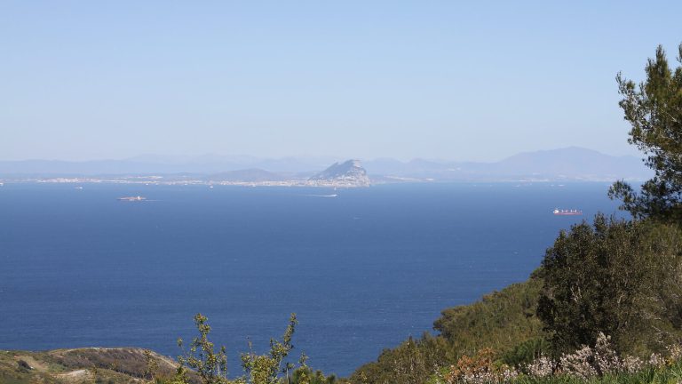 Vista del Estrecho de Gibraltar desde la costa africana, con el Peñón al fondo y barcos cruzando entre las dos orillas
